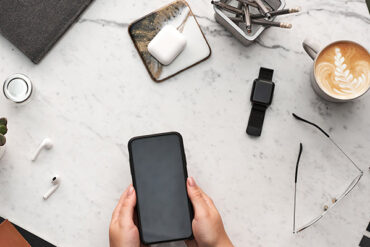 Flatlay met smartwatch, smartpone, koffie en EarPods.