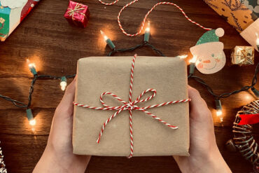 Ingepakt cadeautje met kerstverlichting rondom