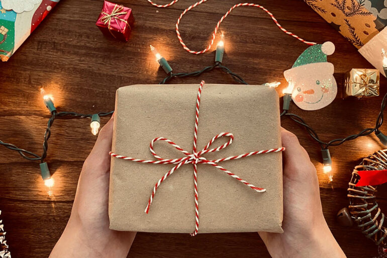 Ingepakt cadeautje met kerstverlichting rondom
