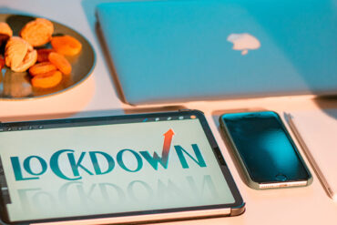 Lockdown geschreven op een ipad, naast een macbook en iphone