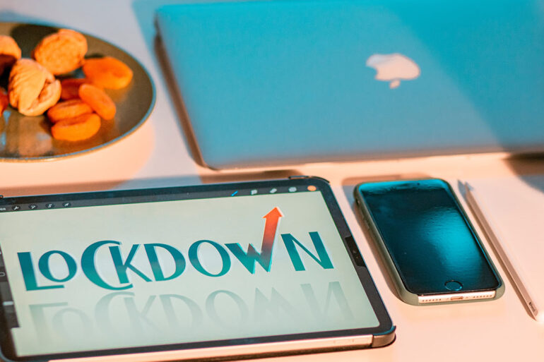Lockdown geschreven op een ipad, naast een macbook en iphone