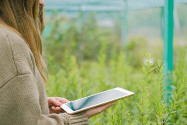 Vrouw met Ipad in tuin