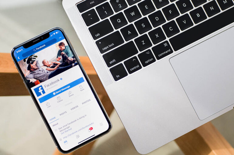 iPhone X met Facebook app naast MacBook