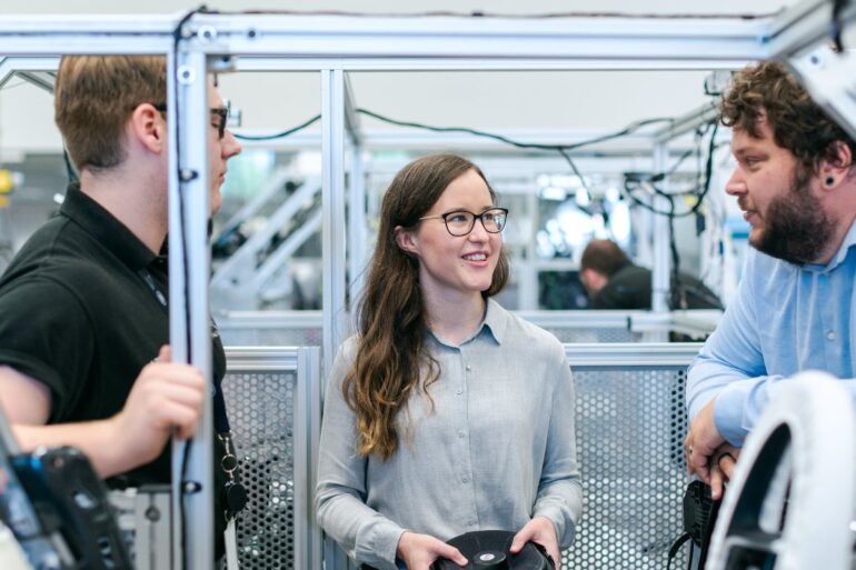 Vrouw en mannen aan het werk in tech