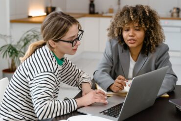 Twee vrouwen achter laptop die samenwerken