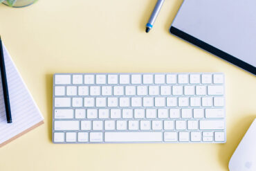 toetsenbord, notitieblok en muis op bureau