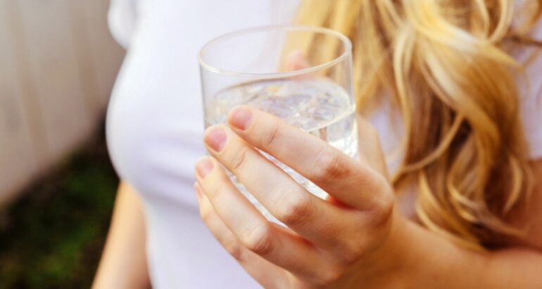 Persoon heeft glas met water in hand