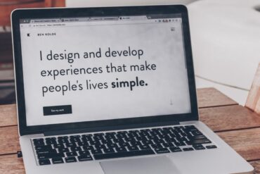 wit met zwarte laptop waarop staat: "i design and develop experiences to make people's lives simple"