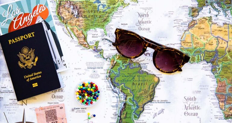 Vakantie flatlay met paspoort, wereldkaart en zonnebril