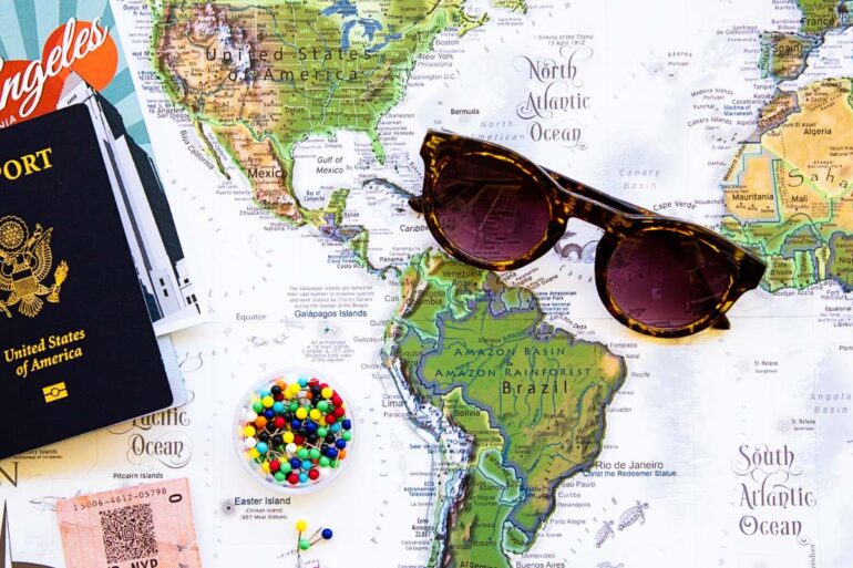 Vakantie flatlay met paspoort, wereldkaart en zonnebril