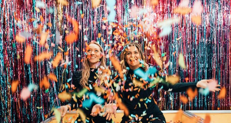 twee-vrouwen-knielen-terwijl-confetti-gooien