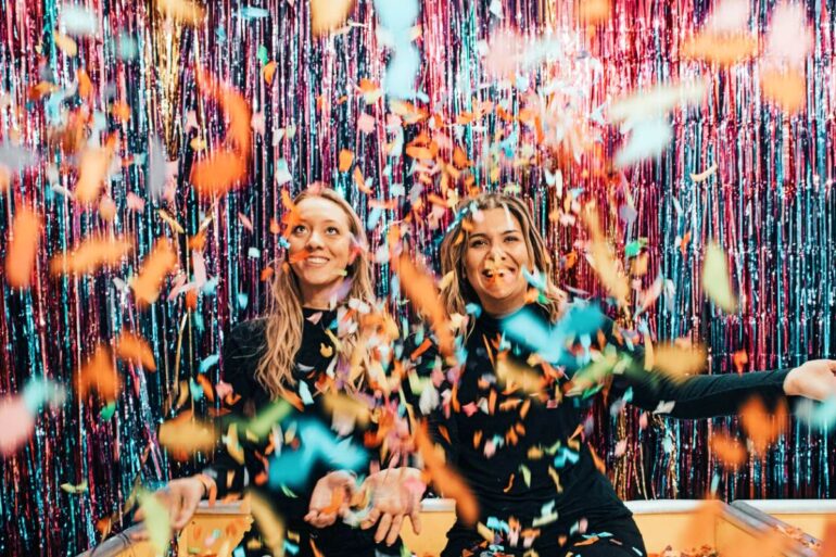 twee-vrouwen-knielen-terwijl-confetti-gooien