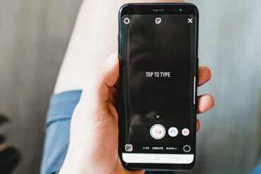persoon houdt zwarte android telefoon vast