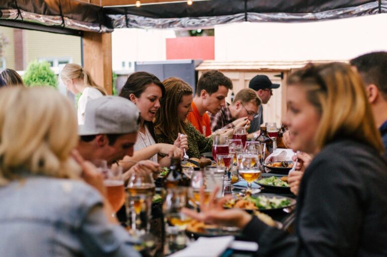 mensen die aan een tafel samen het eten en drinken zijn