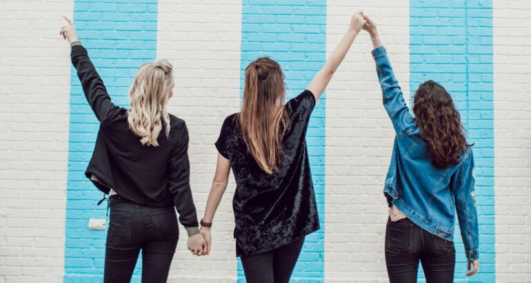 3 vrouwen die ellkaars handen vasthouden