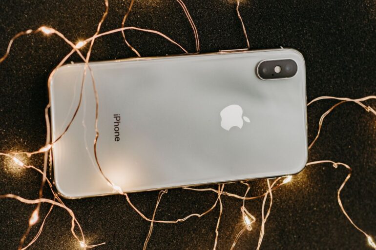 zilver-iphone-x-liggend-op-vooraf-verlichte-lichtslingers