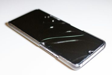 a close up of a cell phone on a white surface